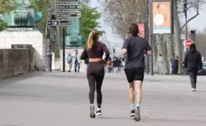 Two runners training side by side on a quiet road, preparing for a 15km event with focused strides