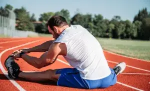 Runner sitting and stretching after a run to cool down