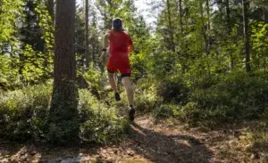 Runner training uphill on a forest slope with strong cadence