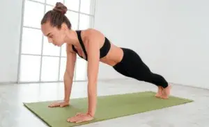 Athlete performing seal walk exercise on gym floor