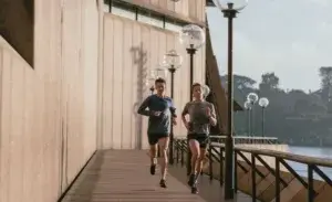 Two runners doing strides running next to building