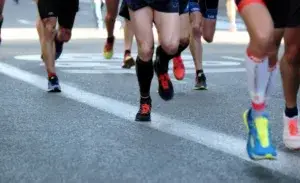 Runners during a competitive race focusing on achieving a 24 min 5k goal, showcasing strong pacing and race day effort.