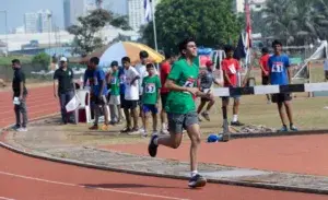 Teen runner finishing strong on the track during a 28 minute 5K race.