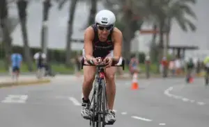 Athlete competing in a beginner sprint triathlon, riding a time trial bike during the cycling leg of the race.