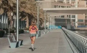 Runner enjoying morning workout along waterfront promenade during sunrise