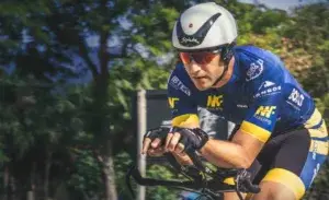 Triathlete riding an aerodynamic bike during a race, showcasing the best triathlon bike for a beginner with aero bars and proper cycling posture.