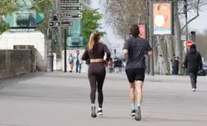 Two people doing light cardio on rest day with an easy run through a city park.