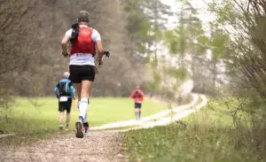 Trail runner with trekking poles during Leadville Trail Marathon on a winding dirt path