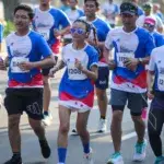 Group of marathon runners wearing matching shirts representing their running team at a city race – perfect example of marathon running team names in action