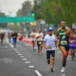 Runners executing negative split pacing during a marathon race on a city street.