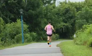 Runner training on a humid day in summer. Running in the heat on a forested path