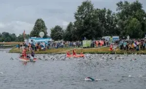 Triathlon swim start with safety teams and spectators, showcasing the first stage of a triathlon event.