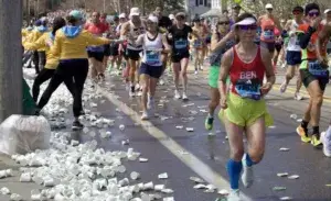 Runners passing a hydration station during a race featured in the 14 Week Beginner Half Marathon Training plan.