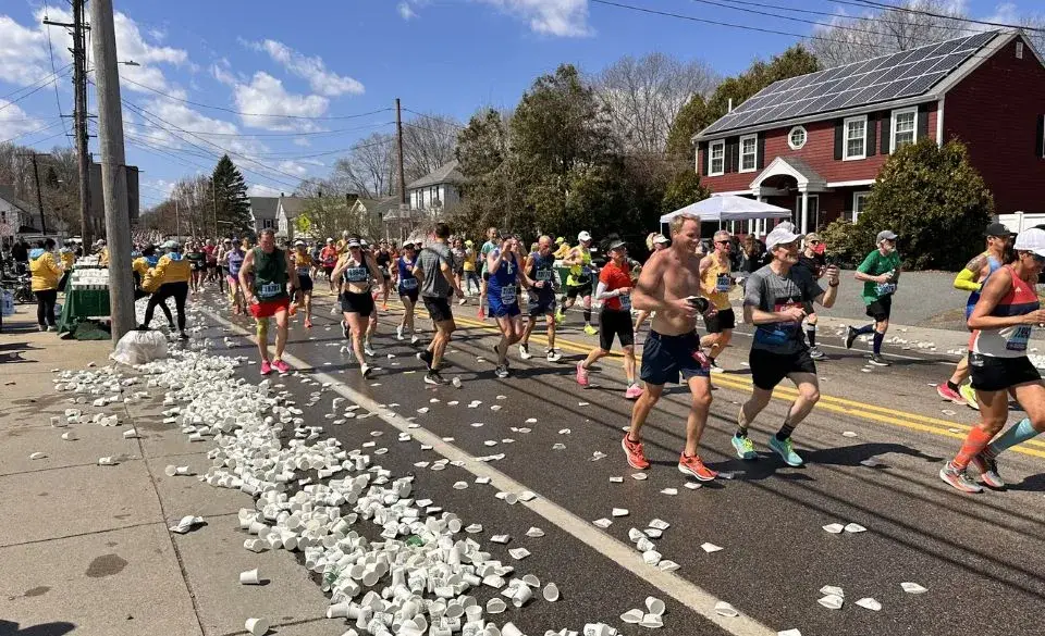 Runners maintaining 3 45 marathon pace at hydration station during race
