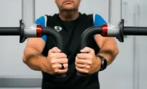 Man performing upper body cardio exercises without legs using arm ergometer.