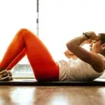 Woman doing exercises at home on a yoga mat