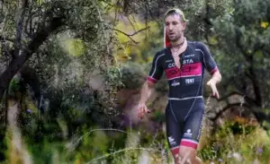 Triathlete running through trail during Ironman 70.3 training time per week.