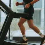 Man working out on incline treadmill in gym for stairmaster vs incline treadmill comparison