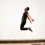 Man demonstrating explosive height in midair, illustrating vertical jump standards by age.