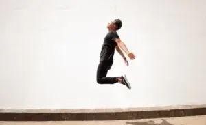 Man demonstrating explosive height in midair, illustrating vertical jump standards by age.