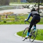 Cyclist performing FTP training on outdoor velodrome track.