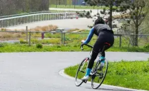 Cyclist performing FTP training on outdoor velodrome track.
