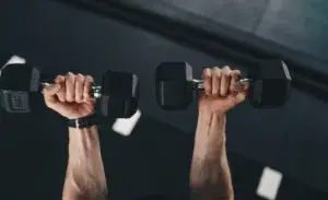 Man performing dumbbell press with close grip targeting the inside tricep workout for medial head activation.
