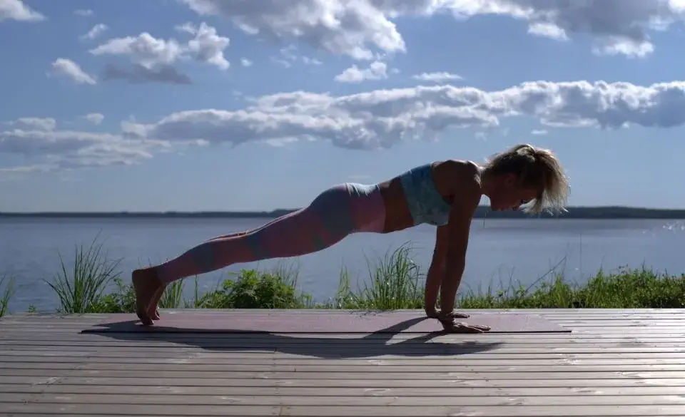 Runner performing plank outdoors near water as part of the best core exercises for runners