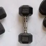 Helms Row dumbbells on gym floor with training shoes