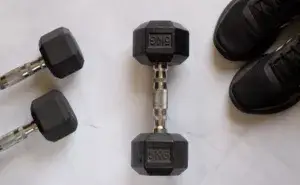 Helms Row dumbbells on gym floor with training shoes