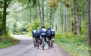 Group of cyclists on a forest road illustrating how many kilometers of cycling is equal to running