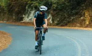 Cyclist climbing a winding hill – road bike vs triathlon bike climbing performance.
