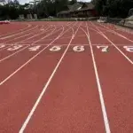 Running coach rates Australia – view of athletics track lanes showing starting positions