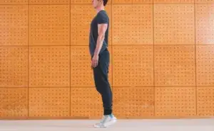 man performing standing toe raises exercise for balance and ankle strength