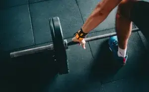 Athlete preparing for a barbell lift demonstrating what does PR mean in gym.