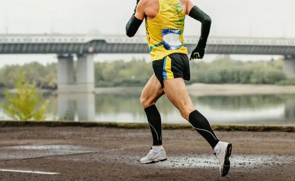 Runner wearing compression arm sleeves during training, showing why do runners wear arm sleeves