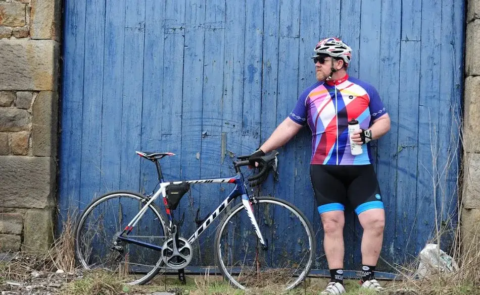 Cyclist standing with road bike after a bicycle workout for weight loss