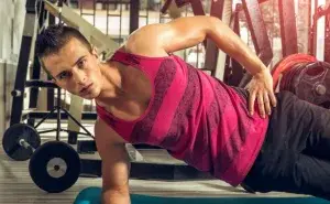 Athlete performing Copenhagen plank in the gym to build core and hip stability