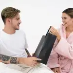 Couple exchanging presents indoors, symbolizing thoughtful gifts for cyclists