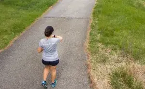 Runner checking watch during half marathon training on a quiet path