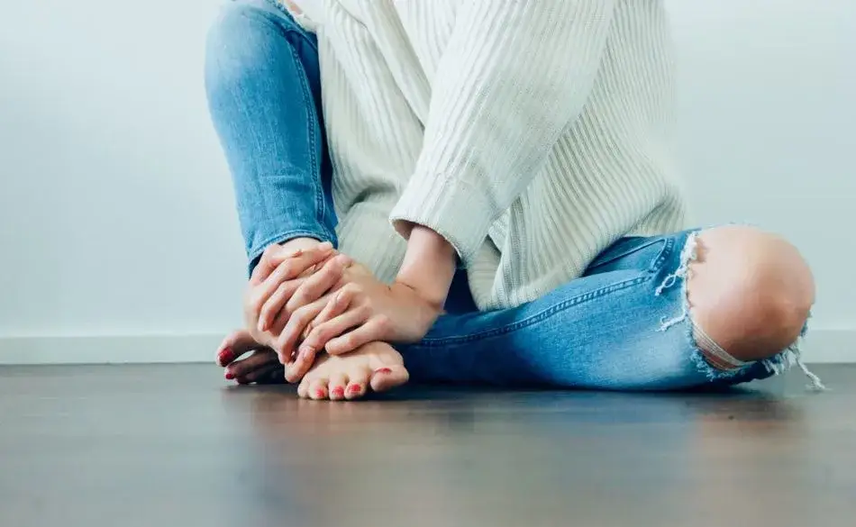 Person holding their foot in pain, symbolizing how to cure plantar fasciitis in one week