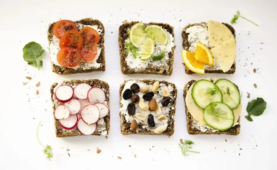 Low calorie snacks for runners including whole grain bread with fresh vegetables, fruit, cheese, and nuts