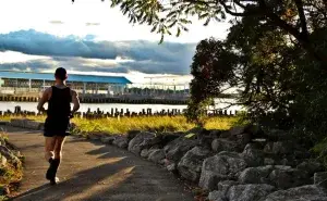 Runner training outdoors on a riverside path during sunset as part of marathon race training