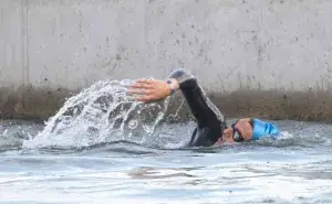Triathlete swimming in open water managing swimmer’s elbow with proper technique