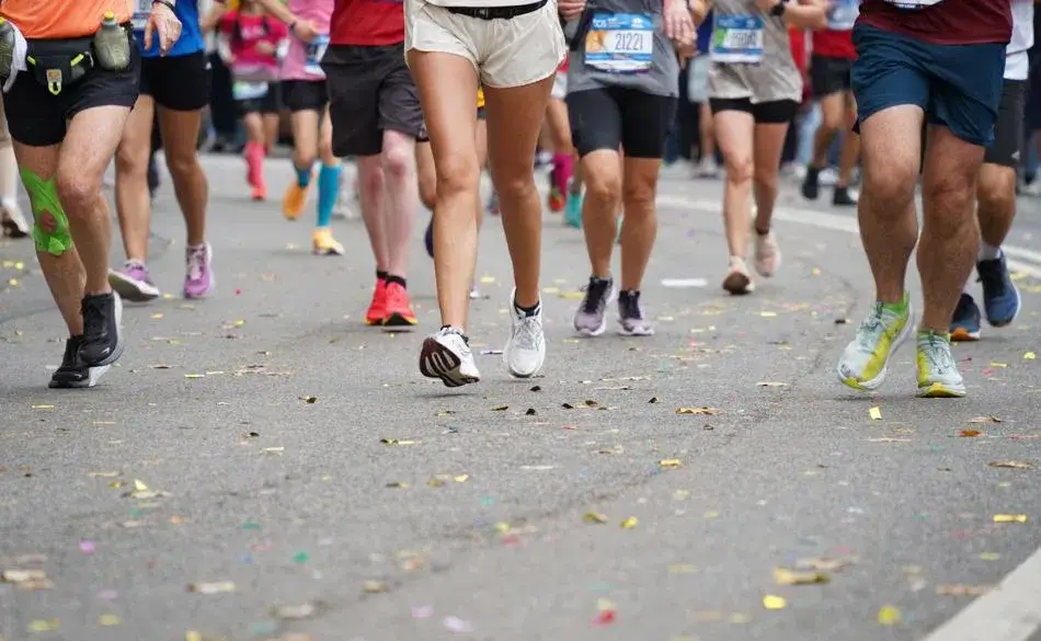 Runners crossing the finish line after completing an 11 weeks to train for a half marathon program