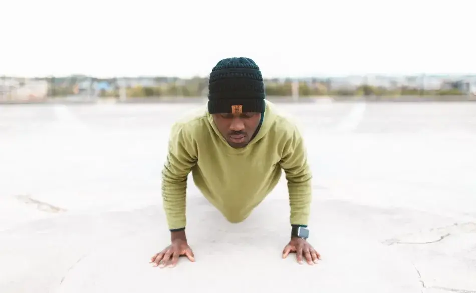 Man doing push-ups outdoors as part of 7 exercises to do everyday routine