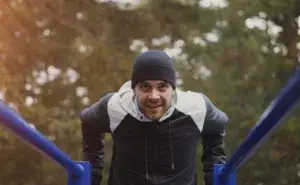 Triathlete performing outdoor dips as part of bodyweight chest exercises routine