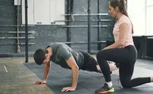 coach watching athlete perform plyometric push-ups during strength training