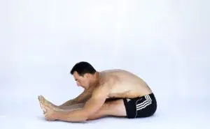Man performing a deep hamstring stretch to improve flexibility and reduce tightness in the legs