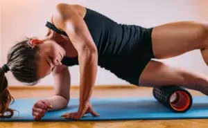 A woman using a foam roller on her IT band during recovery training, illustrating why the foam roller hurts your IT band when used incorrectly.